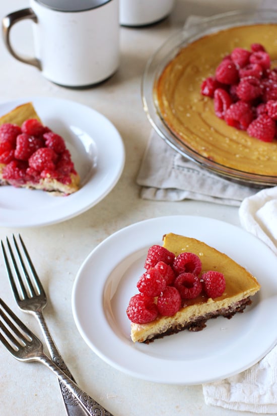 Two slices of Raspberry Pumpkin Ricotta Pie with the full pie in the background.