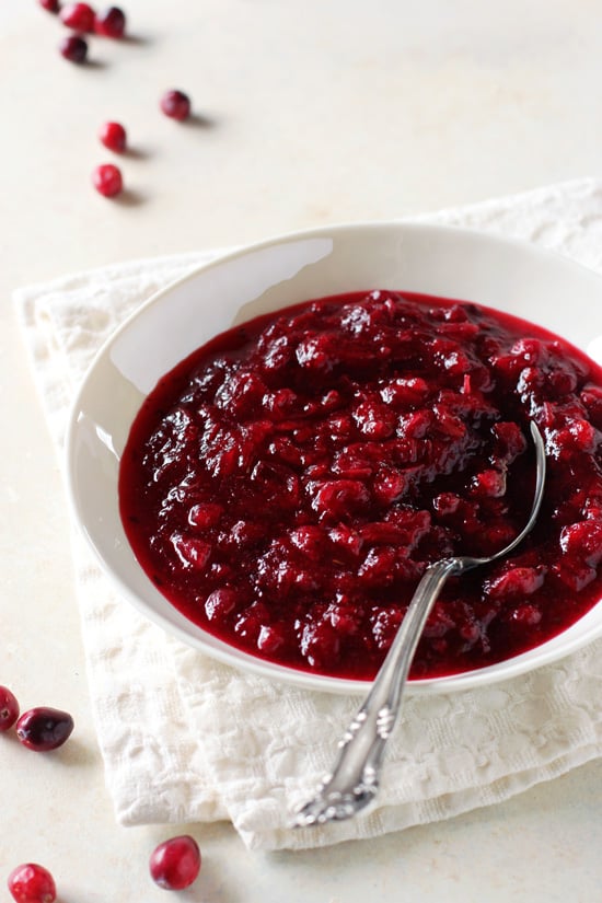 A white bowl filled with Homemade Vanilla Thyme Cranberry Sauce.