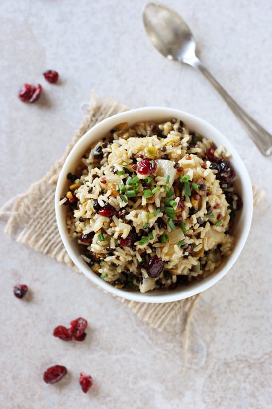 A white bowl filled with Wild Rice Pilaf with a spoon to the side.