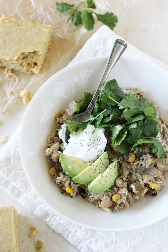 A white bowl filled with Crockpot Chicken Green Chili with a spoon in the bowl.