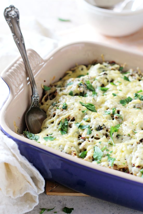 A blue baking dish filled with Pulled Pork and Mushroom Quinoa Casserole.