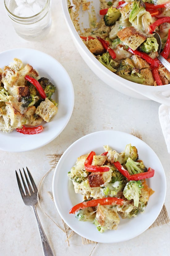 Two white plates filled with Broccoli Cheese Breakfast Casserole with a baking dish to the side.