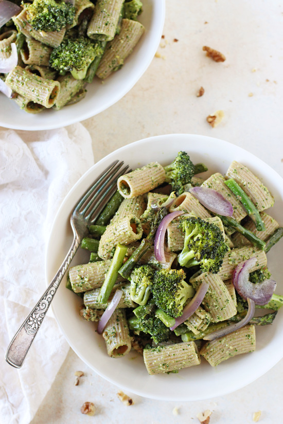 Two white bowls filled with Green Pesto Pasta with a fork in one bowl.
