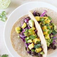 Simple and healthy black bean tacos with mango salsa! With smoky black beans, a sweet mango salsa and crunchy red cabbage! Colorful and fresh!