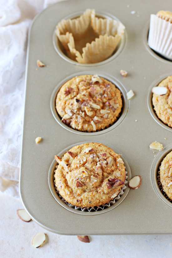 A gold muffin tin filled with Carrot Orange Muffins.
