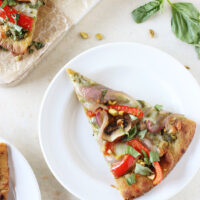 Quick and flavorful veggie and pesto flatbread pizza! With colorful veggies, a pistachio pesto and naan bread! So fun for Spring and Summer!