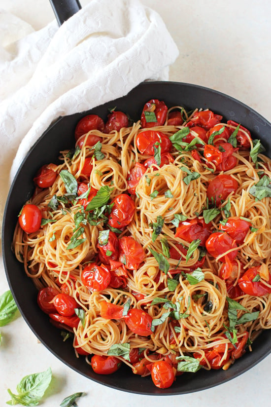 A black skillet filled with Cherry Tomato Sauce mixed with pasta. 