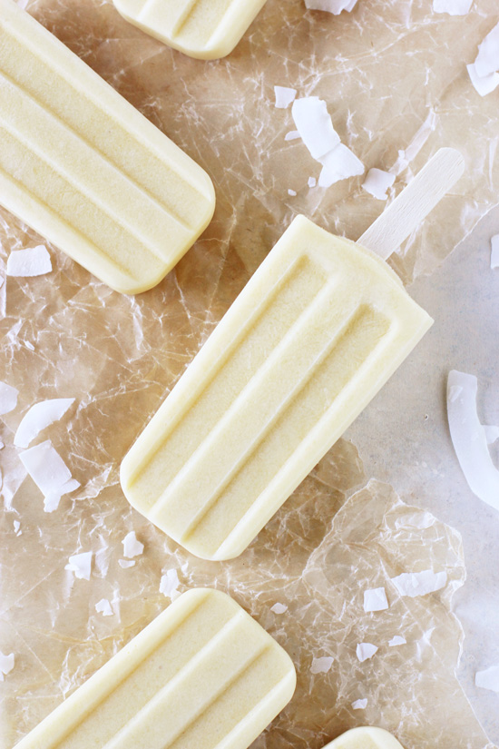 Several Mango Coconut Popsicles on crinkled wax paper.