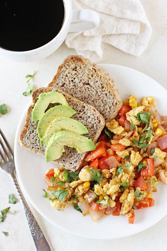 A white plate filled with Southwest Egg Scramble and avocado toast.