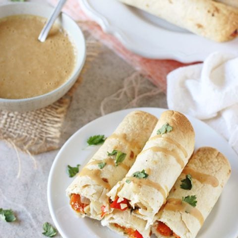 Filled with colorful veggies, cashews and fresh ginger, these baked thai vegetable taquitos are a family favorite! Served with an orange peanut sauce for dipping!