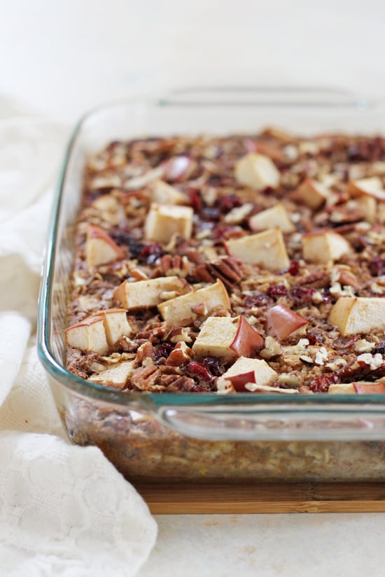 A glass baking dish filled with Cranberry Apple Baked Oatmeal with a white napkin to the side.