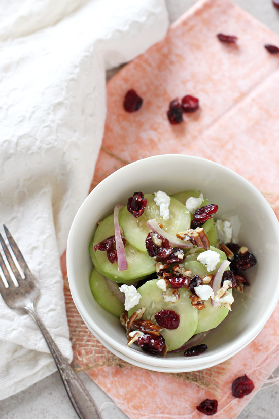A small white bowl filled with Cranberry Cucumber Salad with a fork to the side.