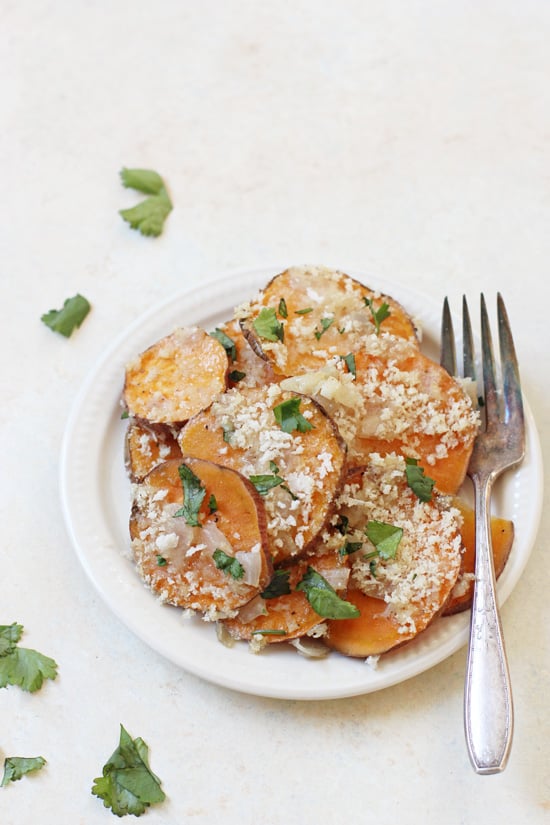 A serving of Healthier Sweet Potato Gratin on a white plate with a fork.