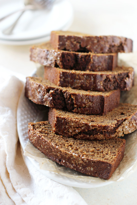 Slices of Healthy Maple Gingerbread on a white platter with a napkin to the side.