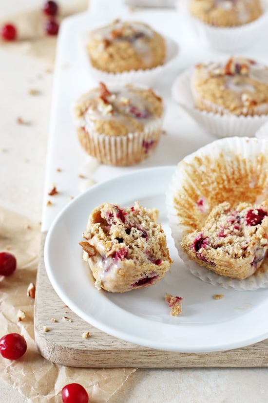 A Cranberry Orange Eggnog Muffin split in half with more muffins in the background.