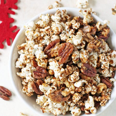 This easy sweet & spicy popcorn nut party mix is completely addicting! Made with fresh rosemary, warm spices and maple syrup!