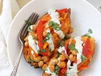 Hearty & healthy buffalo chickpea stuffed sweet potatoes! With a spicy chickpea and veggie filling, and a creamy, cooling ranch drizzle!