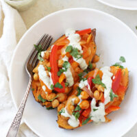 Hearty & healthy buffalo chickpea stuffed sweet potatoes! With a spicy chickpea and veggie filling, and a creamy, cooling ranch drizzle!