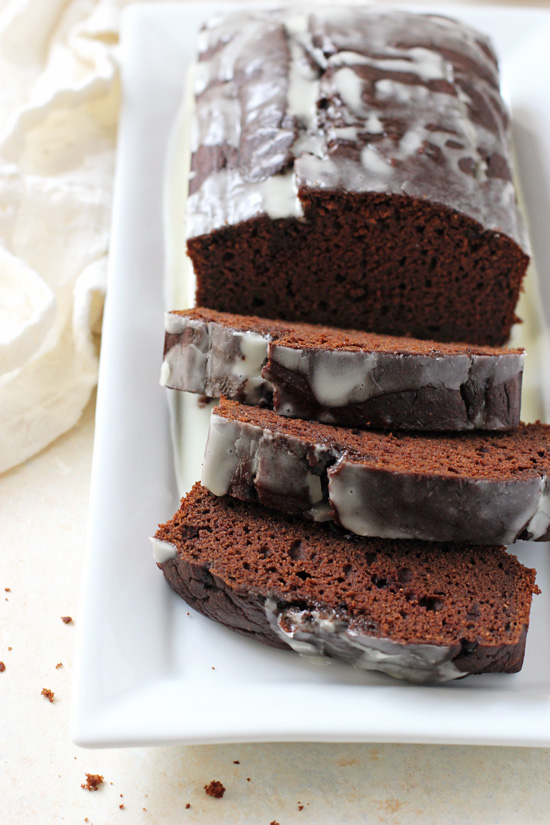 A glazed loaf of Chocolate Sweet Potato Bread with a few slices cut out.