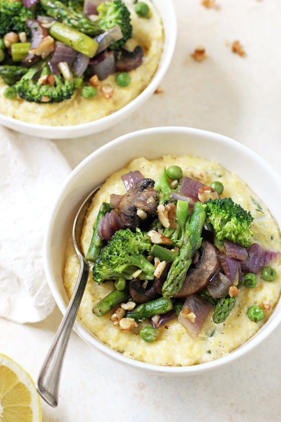 Two bowls of Spring Polenta Primavera with a spoon in one.
