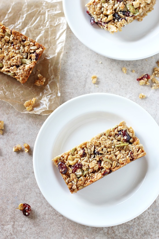 Three Chewy Fruit & Nut Granola Bars on white plates and wax paper.