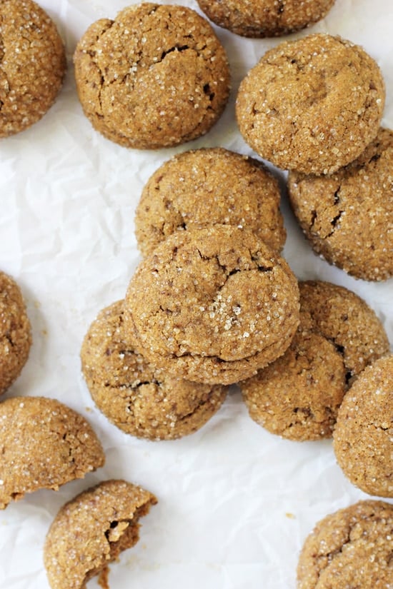 An overhead view of Chewy Pumpkin Cookies scattered on crinkled parchment paper.