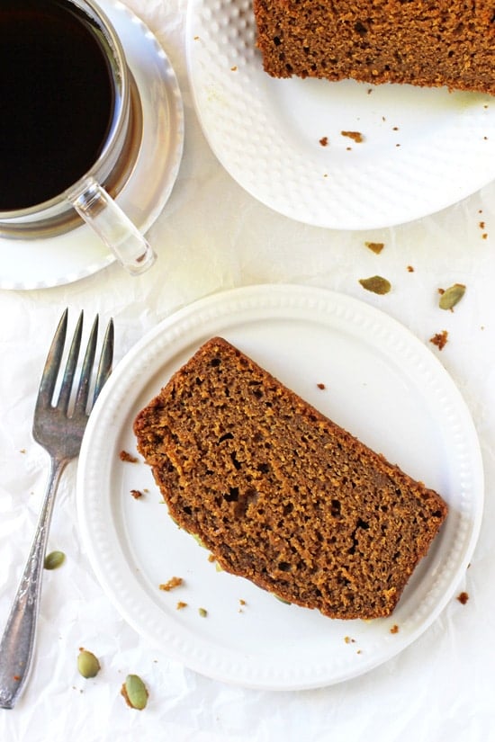 Two slices of Pumpkin Olive Oil Bread with a cup of coffee and a fork.