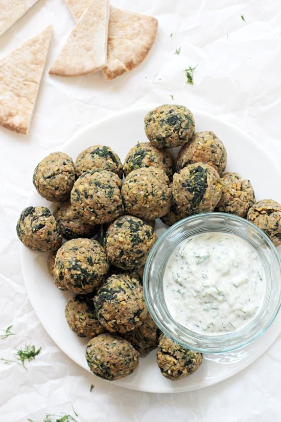 Greek Vegetarian Meatballs on a large white platter with tzatziki sauce in a small bowl.