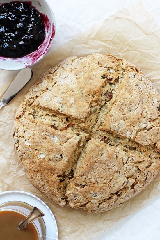 A whole loaf of Whole Wheat Irish Soda Bread with jam and coffee off to the side.