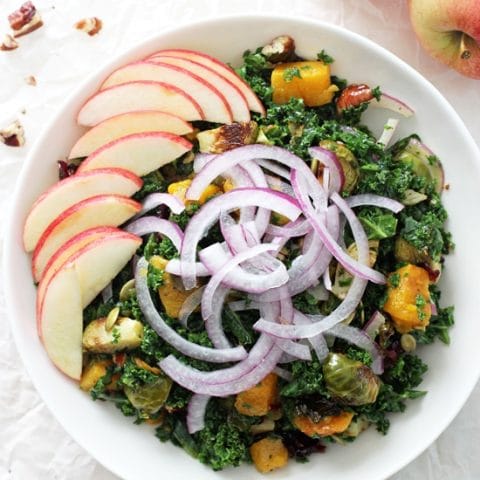 Easy fall harvest kale salad! This hearty and healthy salad is filled with massaged kale, roasted brussels sprouts, butternut squash, crunchy pecans and sliced apple! All tied together with a dreamy maple vinaigrette! Vegan and gluten free! And perfect for the holidays!