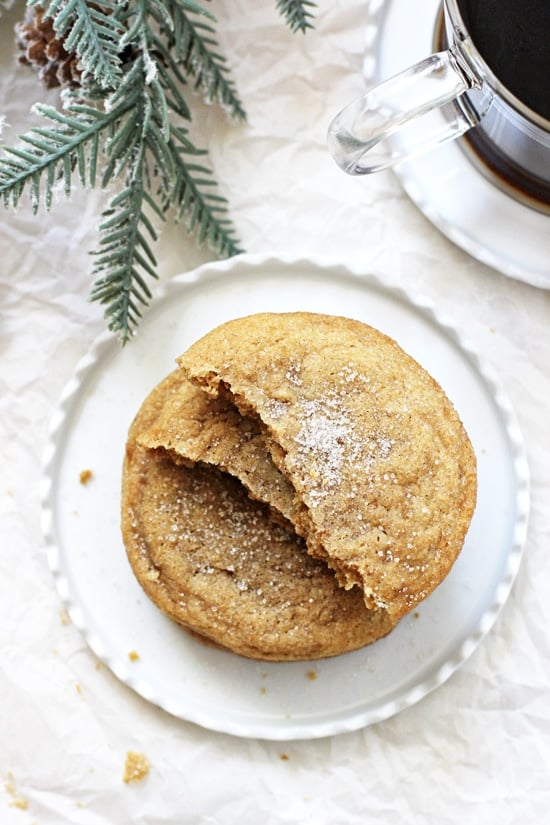 An overhead photo of a stack of Soft & Chewy Cardamom Spice Cookies with greenery and coffee in the background.