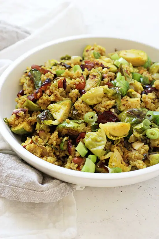 A large white bowl filled with Cranberry Quinoa Salad with a grey and white napkin on the side.