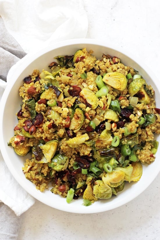 An overhead photo of Cranberry Quinoa Salad in a white bowl with a grey and white napkin on the side.