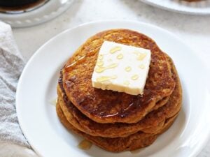 Tender, fluffy, melt-in-your mouth vegan sweet potato pancakes! These easy and healthy pancakes are filled with sweet potato puree, almond milk, cinnamon and olive oil! And they reheat beautifully, making them perfect for busy mornings!