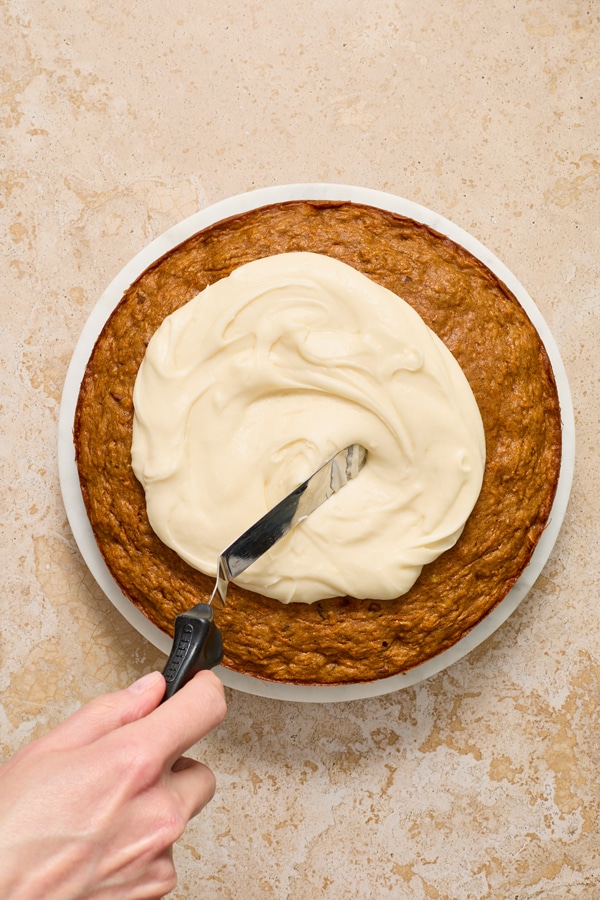 Dairy Free Cream Cheese Frosting being spread over a cake.
