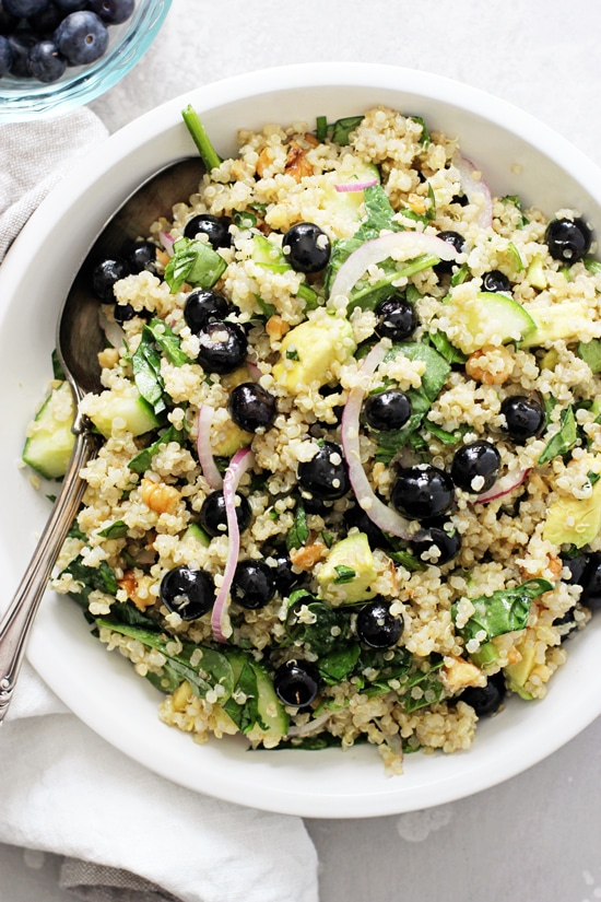 A white bowl filled with Blueberry Quinoa Salad with a serving spoon in the dish.
