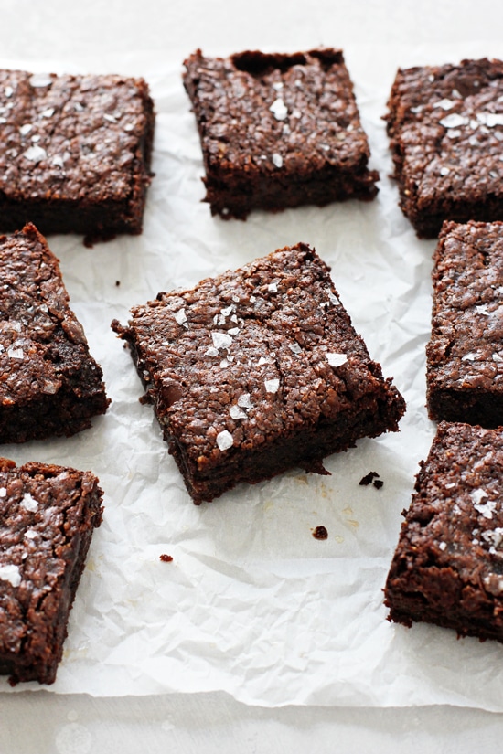 Several Olive Oil Brownies on white parchment paper.