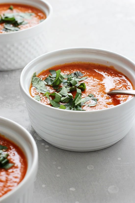 Three white bowls filled with Vegan Tomato Soup.