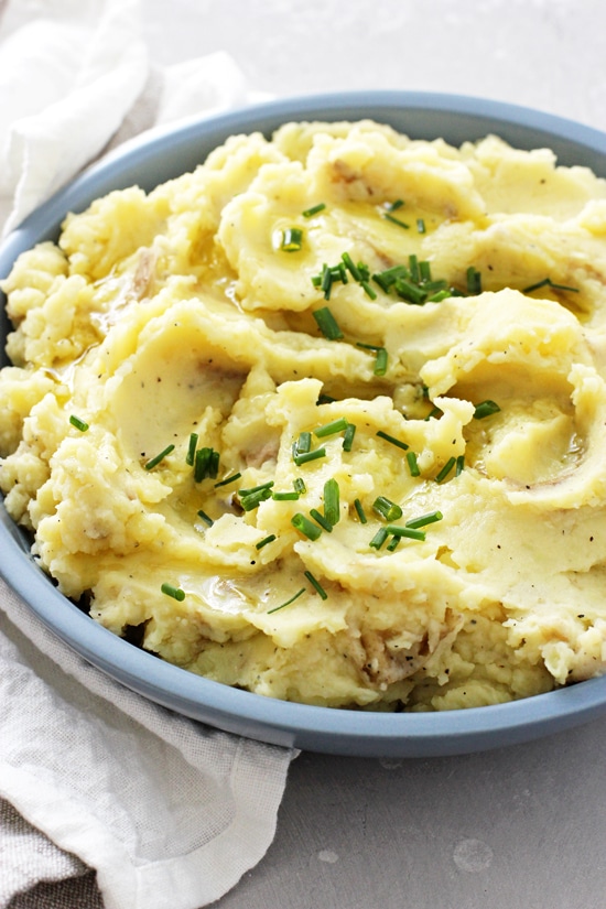 A blue bowl filled with Olive Oil Mashed Potatoes and a white napkin.