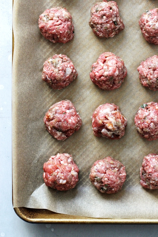 Uncooked Egg Free Meatballs on a parchment lined baking sheet.