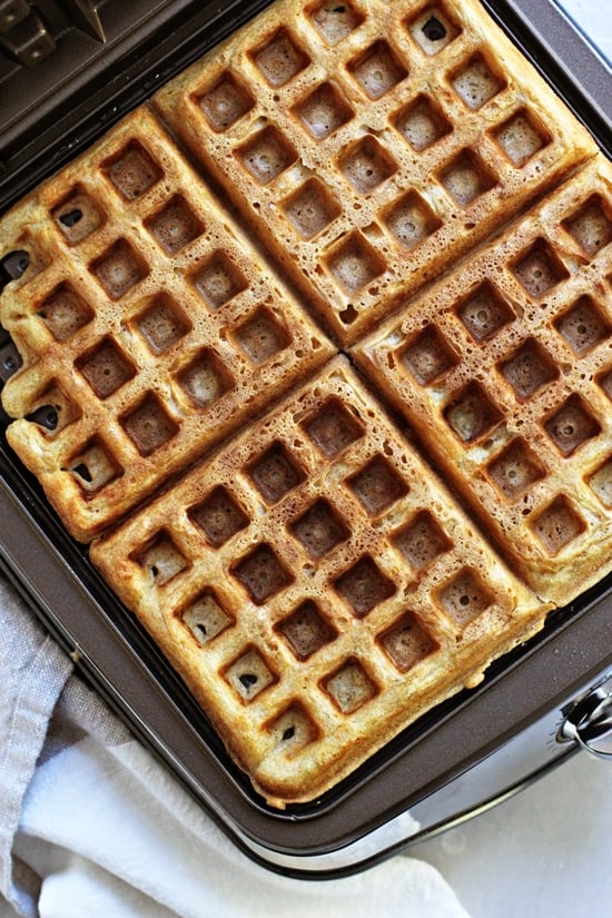 Waffles cooking in a waffle maker.