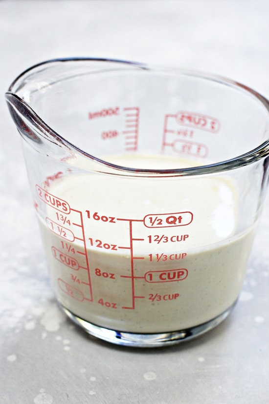 Homemade dairy free alfredo sauce in a liquid measuring cup.