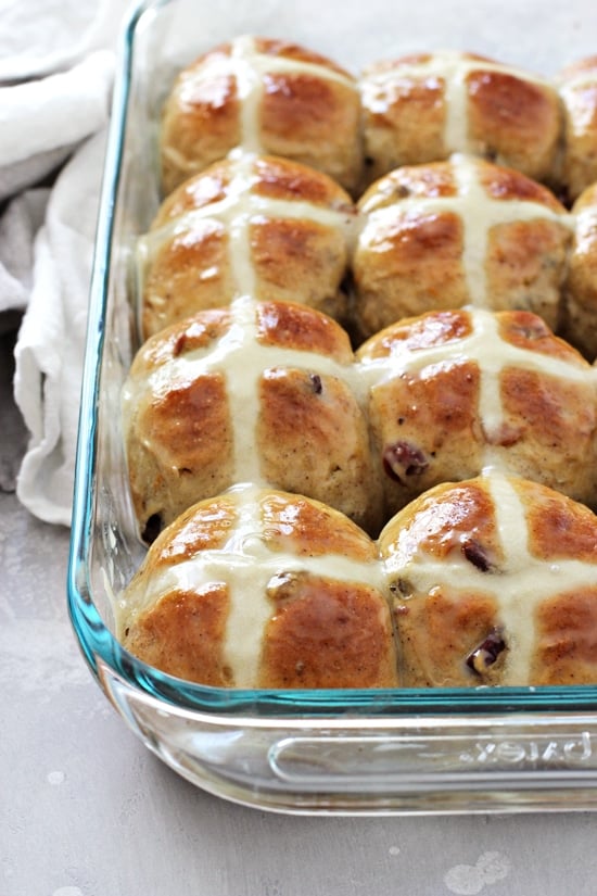 A glass baking dish filled with glazed Lactose Free Hot Cross Buns.