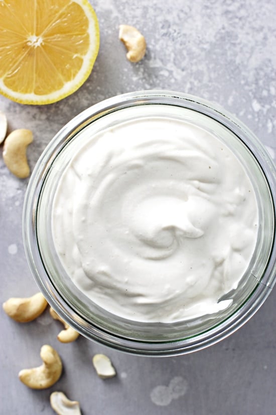 Non Dairy Sour Cream in a glass jar with cashews scattered around.