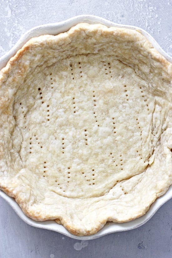 A baked Vegan Pie Crust in a white pie plate.