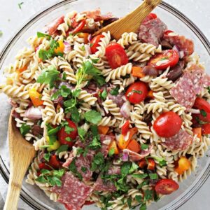 A glass mixing bowl filled with Dairy Free Italian Pasta Salad.