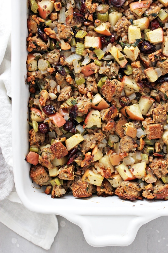 A white baking dish filled with Dairy Free Apple Walnut Stuffing.