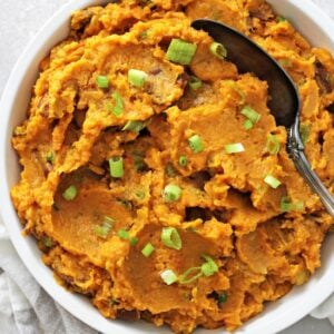 A white bowl filled with Dairy Free Mashed Sweet Potatoes.