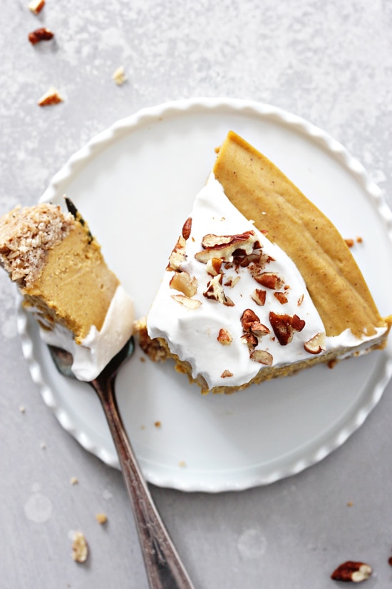 A slice of Vegan Pumpkin Cheesecake with a bite taken out with a fork.
