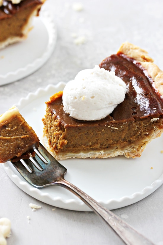 A slice of Dairy Free Pumpkin Pie with a bite taken out with a fork.